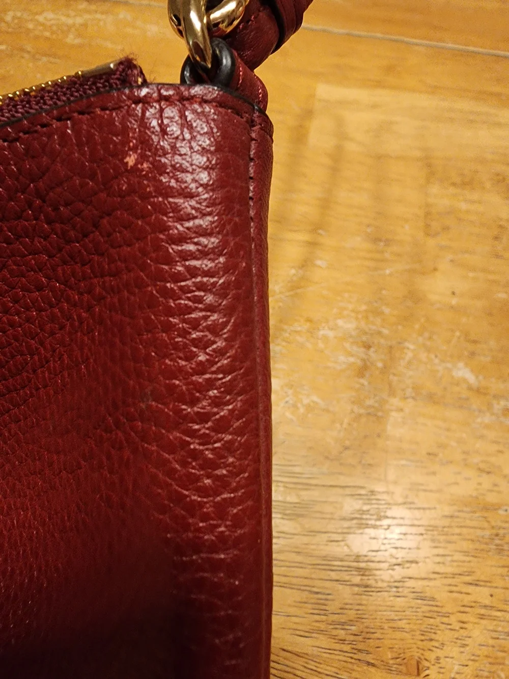 red polished pebble leather Coach wristlet, featuring gold-tone hardware